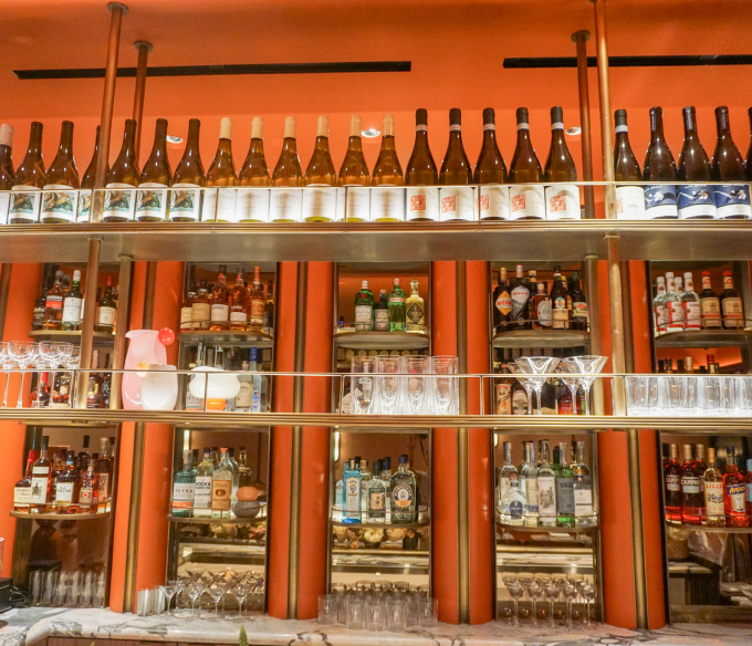 Wine and liquor bottles displayed on custom metal shelves, designed and fabricated by Renfrow+Co for a hospitality project